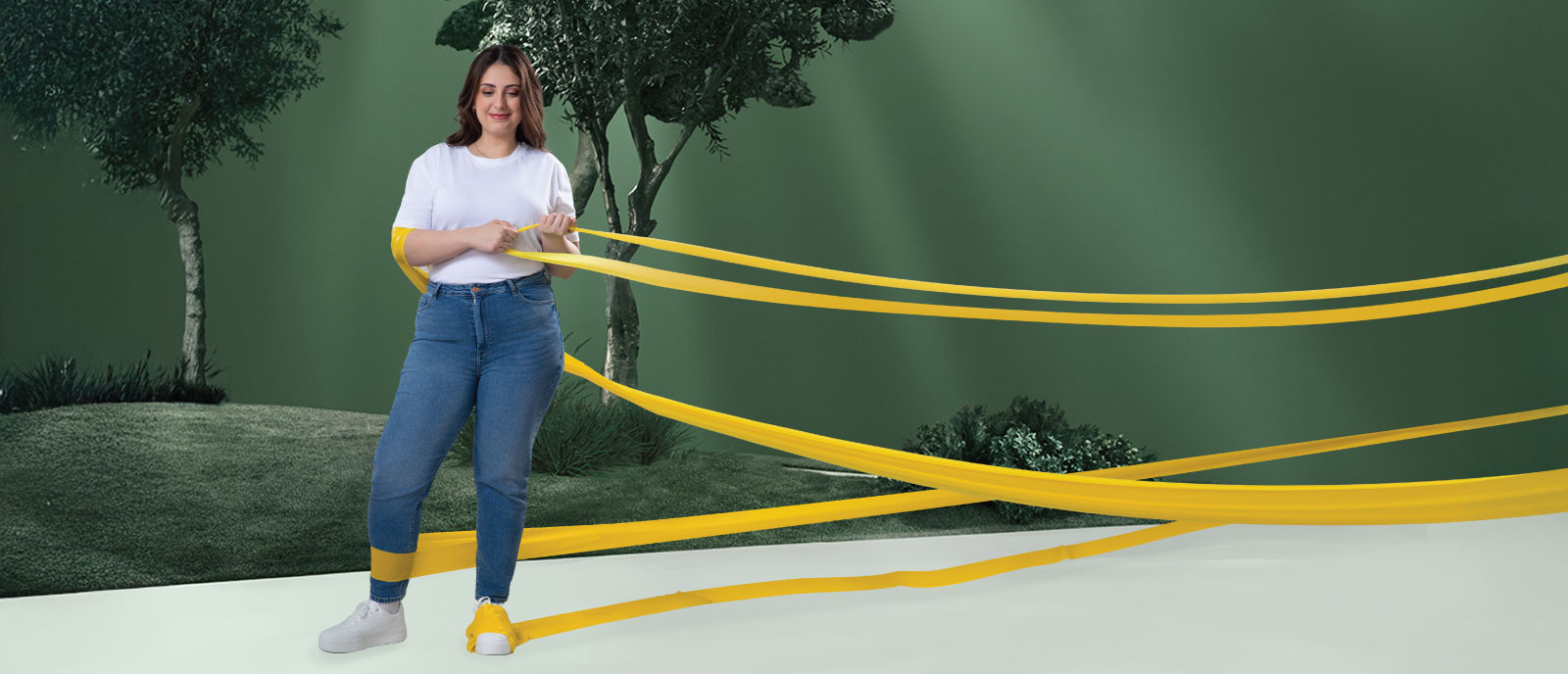 Uma mulher com obesidade, num parque, a remover as faixas de resistência dos seus braços, enquanto continua a ter as faixas à volta das pernas.